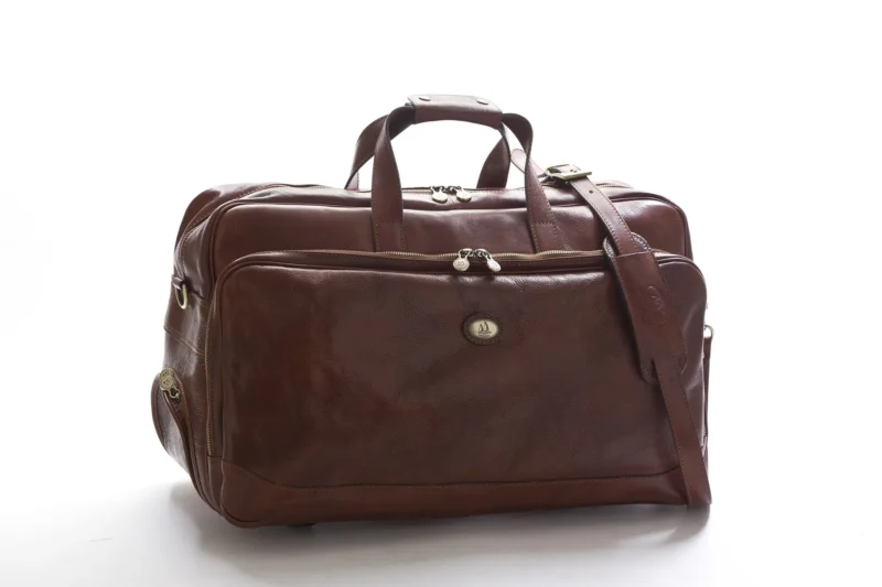 Large travel trolley bag in Tuscan leather with two wheels, handles and removable strap